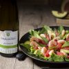 photo d'une bouteille de vin avec un plat de mangue et crevette