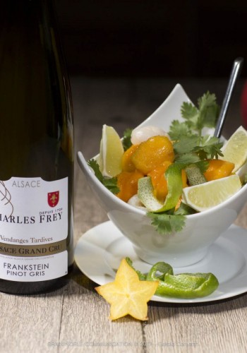 Photo d'une bouteille de Grand cru avec un plat de fruits
