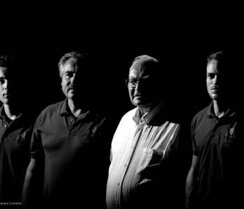 4 hommes cotes à cote en noir et blanc