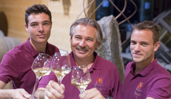 photo de trois hommes en tee shirt rouge avec chacun un verre de vin